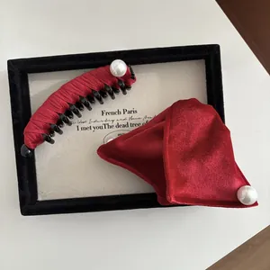 Dettaglio di fermaglio per capelli in velluto rosso e fiocco con perle fini