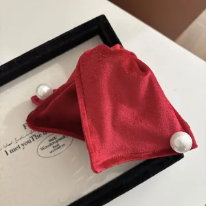 Dettaglio di fiocchi per capelli in velluto rosso con eleganti perle in cornice