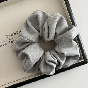 Close-up of a grey knitted scrunchie with soft ribbed texture in a minimalist tray