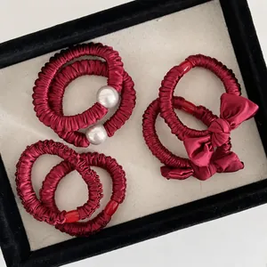 Burgunderfarbenes Satin-Haargummi-Set mit Perlen und Schleifen in einer Schmuckschatulle