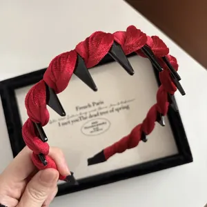 Dettaglio del cerchietto in velluto rosso intrecciato con denti a pettine per presa