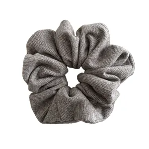 Grey ribbed knit oversized scrunchie with soft elastic texture on white background