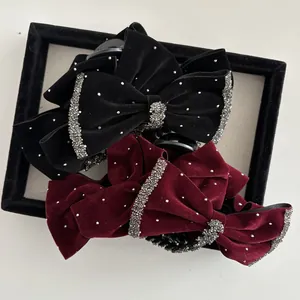 Detailed macro view of black and wine red velvet hair claws with shimmering rhinestones