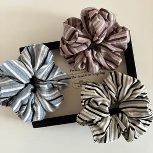 Three-pack of vintage striped knit scrunchies in blue, brown, and black patterns