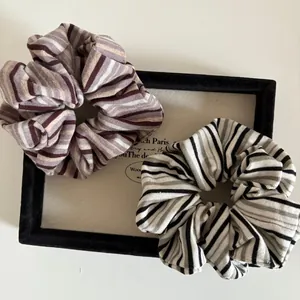 Detailed view of two-piece striped fabric scrunchies in a vintage display tray