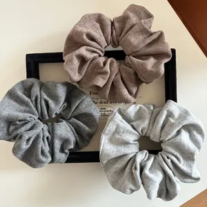 Three-piece set of soft ribbed knit scrunchies in coffee, dark grey, and light grey shades