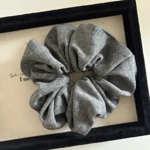 Close-up of gray knit oversized scrunchie showing detailed vertical ribbed texture