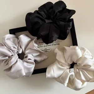 Three-piece set of elegant satin hair scrunchies in black, silver gray, and cream white