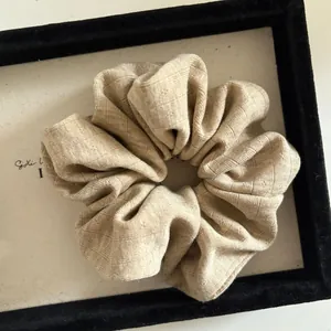 Macro shot of minimalist beige ribbed knit scrunchie texture in a velvet display box