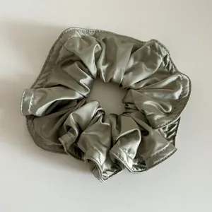 Nahaufnahme des jadegrünen Satin-Haargummis mit feiner Textur und sauberer Naht
