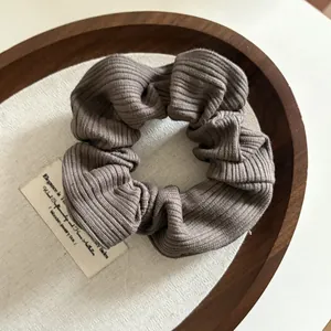 Gros plan du chouchou en maille côtelée marron avec texture verticale détaillée