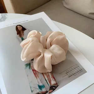 Détail du chouchou en satin champagne avec brillance douce sur magazine de mode