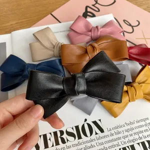 Detailed view of a handmade PU leather bow hair clip in black with a textured finish