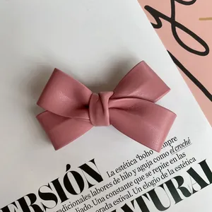 Detailed close-up of pink PU leather bow hair clip showing elegant texture and craftsmanship