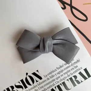Detailed macro view of the grey PU leather texture on the cross bow hair clip