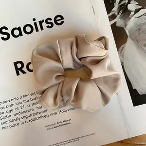 Détail d'un chouchou en satin élégant avec texture plissée douce sur fond de magazine de mode