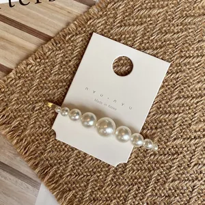 Détail d'une pince à cheveux en perles faite main sur une carte de présentation chic