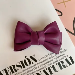 Detail of the layered magenta leather bow hair clip with fine lychee grain texture