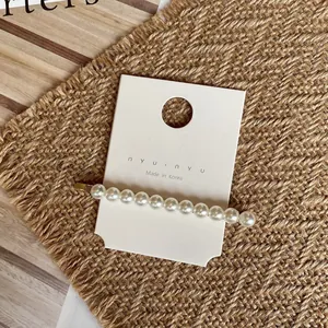 Détail d'une barrette à perles faite main sur une carte de présentation en bijoux