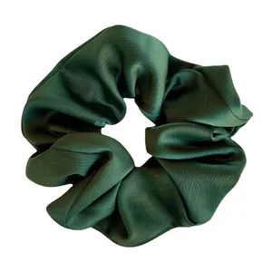 Chouchou en satin vert foncé texturé avec brillance douce et plis élégants sur fond blanc