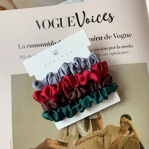 Detail view of four-piece set silk satin scrunchies in gray, burgundy, brown and dark green