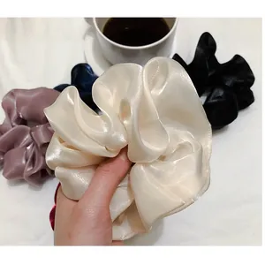 Chouchous élégants en satin aux couleurs variées sur un tissu blanc texturé de luxe