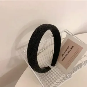 Détail d'un serre-tête épais gris foncé en éponge dans un petit panier blanc