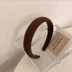 Détail d'un serre-tête en éponge rembourré marron chocolat avec un tissu en coton texturé