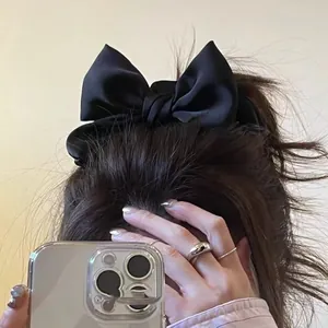 Elegant large black satin bow hair tie accessory for women with a silky glossy finish