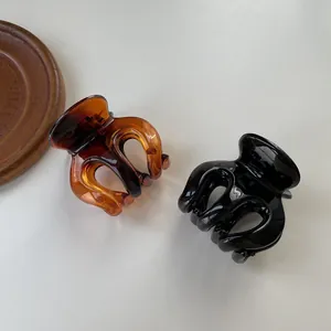 Detail of amber tortoiseshell and glossy black hair clips with secure multi-tooth grip