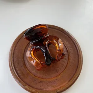 Macro detail of amber tortoiseshell hair claw with a glossy translucent finish