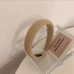 Détail d'un serre-tête épais en éponge beige avec une étiquette faite main dans un panier