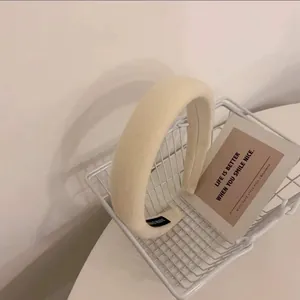 Détail d'un serre-tête en éponge crème avec étiquette artisanale dans un panier