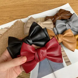 Vintage PU leather bow hair clip set for women in various retro colors on rustic background