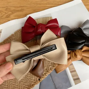 Vintage leather bow hair clip for women in assorted colors with a secure metal duckbill grip