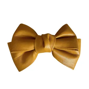 Ginger yellow leather bow hair clip with textured finish in minimalist French style