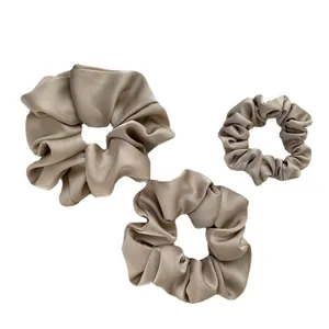 Three-piece champagne satin scrunchie set in various sizes with elegant silky texture