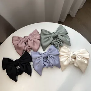 Elegant oversized satin bow hair scrunchies in five pastel colors on white background