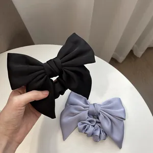 Elegant oversized satin bow scrunchies in black and lilac with premium creamy texture