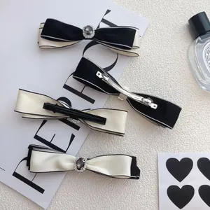 Elegant black and white satin bow hair clips with rhinestones and gemstone accents