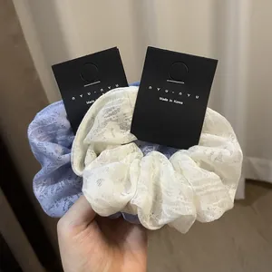 Lace hollow floral hair scrunchies in light blue and white color with fabric texture