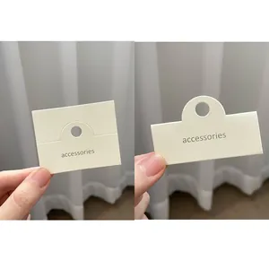 Primer plano de tarjetas de exhibición para joyas color crema con agujero para colgar