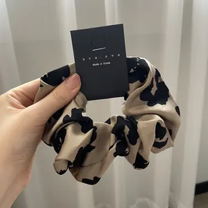 Detail of cow and leopard print hair scrunchies with soft texture on a display card