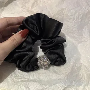 Lussuoso elastico in raso nero con una scintillante fibbia a fiore di camelia diamantata