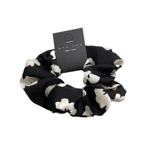 French style floral scrunchie with black and white flower pattern on white background