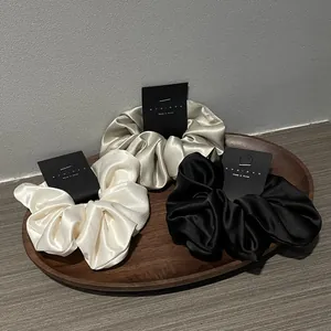 Three-piece satin scrunchie set in black, ivory, and champagne with premium silk-like gloss