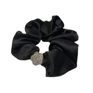 Elegante elastico per capelli in raso nero con fiore di camelia ricoperto di strass