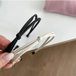 Minimalist knot headband set in black and cream leather for an elegant hair accessory