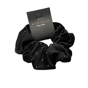 Elegant black velvet scrunchie with silver rhinestone dots and nyunyu branding card