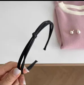 Elegant black knotted headband with dual-band faux leather design for a stylish look